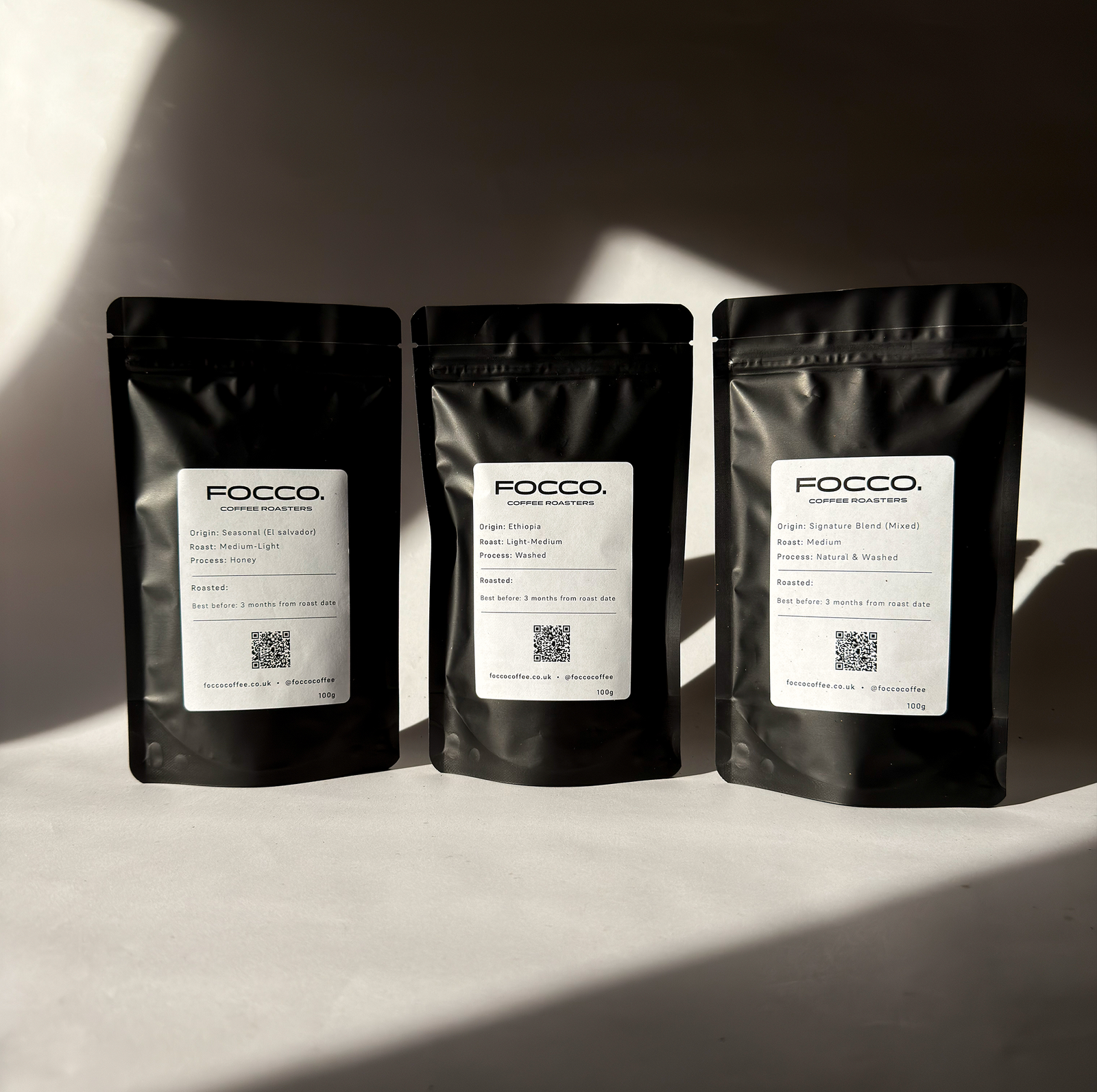 three bags of FOCCO coffee on a shelve with black background.